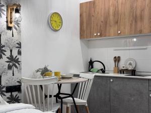 eine Küche mit einem Tisch und einer Uhr an der Wand in der Unterkunft EmmaApart Comfort 11 in Astana + 4 Fotos