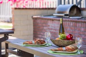 a picnic table with a bowl of food and wine glasses at San Clemente Inn in San Clemente +10 photos