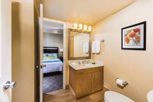 a bathroom with a sink and a toilet and a bed at San Clemente Inn in San Clemente