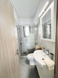 a bathroom with a toilet and a sink and a shower at BlueLine apartment 3 in Loutraki +25 photos