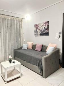 a living room with a couch and a table at BlueLine apartment 3 in Loutraki