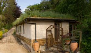 uma pequena casa com relva no telhado em Pathways, Beachwood Cottage em Bath