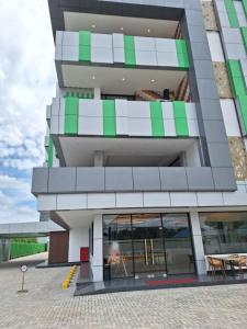 a tall building with green and white balconies at Alltrue Hotel Palangkaraya in Palangkaraya