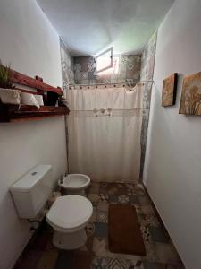 een kleine badkamer met toilet en douche bij La Cholita in Belén