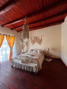 een slaapkamer met een bed en een houten plafond bij La Cholita in Belén