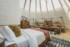 Postel nebo postele na pokoji v ubytování Oso Tipi at El Mistico Ranch