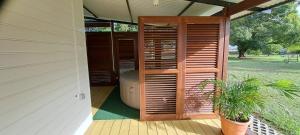 a porch with a wooden shutter on a house at Les Maripas Studio 1 in Rémiré