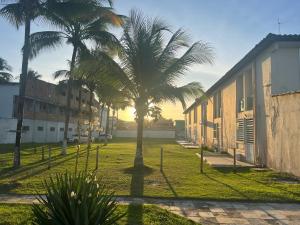 un groupe de palmiers à côté d'un bâtiment dans l'établissement Apartamento frente ao mar na praia do guaibim., à Guaibim
