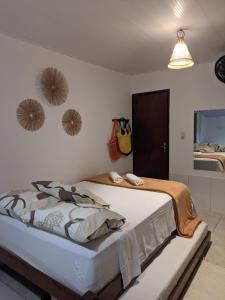 ein Schlafzimmer mit einem Bett und einem Spiegel in der Unterkunft Antunes vila maragogi in Maragogi