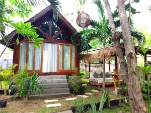 吉利阿尔Bintang Tiga Bungalows Gili Air的一座带床和树的房子
