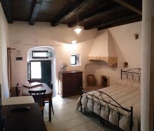a bedroom with a bed and a table in a room at Case Vacanza Al Borgo Antico in Vico del Gargano
