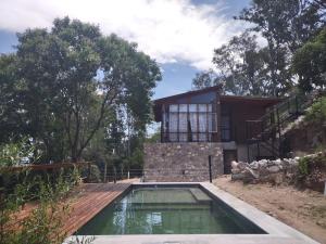 a house with a swimming pool in front of it at Refugio del Valle in La Falda