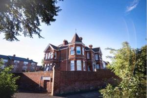 une grande maison en briques rouges avec une tour dans l'établissement BridgeCity Spacious 1 bed flat Maidstone Free Parking, à Maidstone