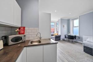 a kitchen with a sink and a microwave on a counter at BridgeCity Glamorous studio Free Parking in Maidstone Town in Kent