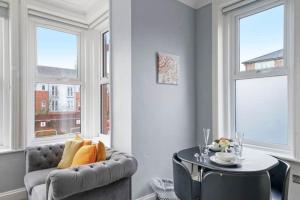 a living room with a couch and a table and windows at BridgeCity Glamorous studio Free Parking in Maidstone Town in Kent