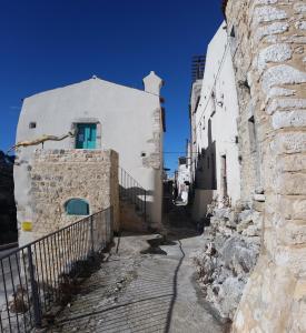 eine Gasse mit einem weißen Gebäude mit einer blauen Tür in der Unterkunft Case Vacanza Al Borgo Antico in Vico del Gargano