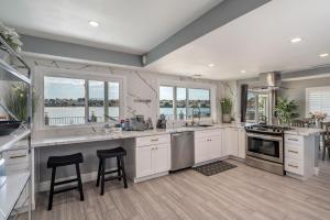 cocina grande con armarios blancos y ventanas en The Lakefront Oasis, en Victorville