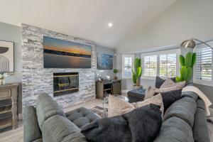 Una sala de estar con un sofá y una chimenea. en The Lakefront Oasis, en Victorville