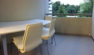 a white table and chairs on a balcony at Lucerne O-Guetsch in Lucerne