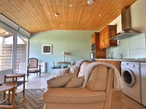 a living room with a couch and a kitchen at Appartement avec jardin privatif et équipements modernes - FR-1-813-9 in Groix