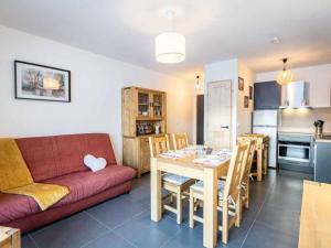 ein Wohnzimmer mit Couch und Tisch und eine Küche in der Unterkunft Appartement moderne avec balcon et parking à Valmorel - FR-1-291-1019 in Valmorel
