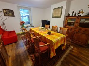 ein Esszimmer mit einem Tisch mit Stühlen und einem roten Sofa in der Unterkunft Charmant gîte entre Nancy et Metz avec terrasse - FR-1-584-362 in Belleville