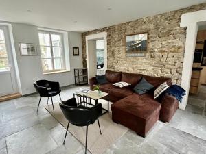 ein Wohnzimmer mit einer Couch und einer Steinwand in der Unterkunft Maison rénovée cœur de Groix, 9 couchages - FR-1-813-13 in Groix