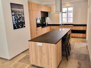 eine Küche mit einer Insel mit einer schwarzen Arbeitsplatte in der Unterkunft Maison rénovée cœur de Groix, 9 couchages - FR-1-813-13 in Groix