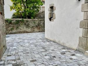 einen steinernen Innenhof mit einer Wand und einem Fenster in der Unterkunft Maison rénovée cœur de Groix, 9 couchages - FR-1-813-13 in Groix