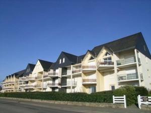 a large apartment building on the side of a street at Étel - Duplex 3 pièces - 42 m² - Piscine - Wifi - Animaux admis - FR-1-479-200 in Étel