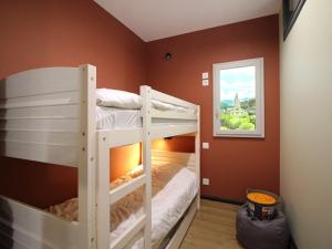 two bunk beds in a room with a window at Appart rénové T2 bis, centre La Bourboule, WiFi, proche thermes - FR-1-608-277 in La Bourboule