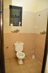 a bathroom with a toilet and a window at Bamburi Phase 4, near Naivas Supermarket in Mombasa