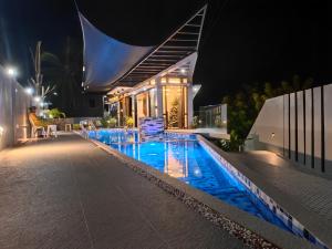 a swimming pool in front of a house at night at Arrow Hill Vacation House in Dalaguete