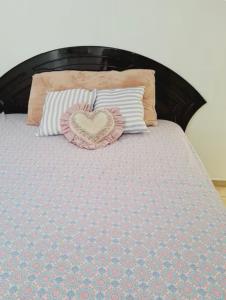 a bed with a heart pillow and pillows on it at Casa vacacional san Miguel in San Miguel