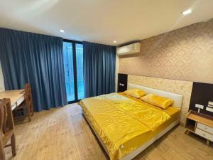 a bedroom with a bed with yellow sheets and a desk at 芭提雅市中心五卧六卫带KTV民宿hw in Pattaya Central