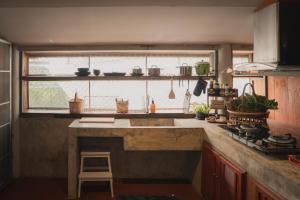a kitchen with a large sink and a window at Baantonmai Farmstay in Ban Mai Ngae