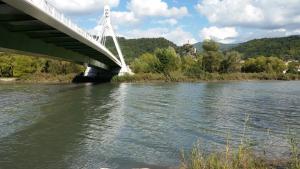 uma ponte sobre um rio ao lado de uma massa de água em Maison La Minoterie em Volonne