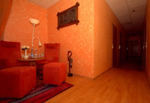 a dining room with orange walls and a table and chairs at Pirčių slėnis in Šniūraičiai