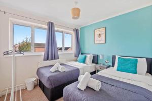 a bedroom with two beds and a window at BridgeCity 4 bedroom house with parking in Maidstone Town in Kent