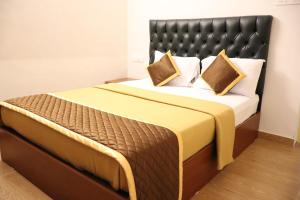 a bedroom with a large bed with a black headboard at Bougainvillea Haven in Varkala