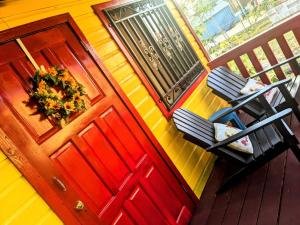 einen Blick über eine Veranda mit einer roten Tür in der Unterkunft Garden Cottage in San Ignacio