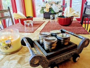 einen Tisch mit einer Kerze und einem Karren mit einem Haufen Tassen in der Unterkunft Garden Cottage in San Ignacio