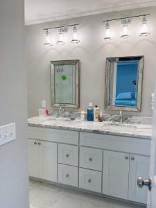 un baño con dos lavabos y dos espejos en Come feel home away from home, en Crawfordville