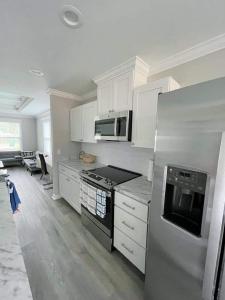 una cocina con armarios blancos y un aparato de acero inoxidable en Come feel home away from home, en Crawfordville