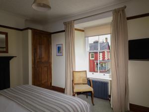 a bedroom with a bed and a window and a chair at Y Talbot in Tregaron +37 photos