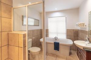 une salle de bain avec une baignoire, des toilettes et un lavabo dans l'établissement Central Wilderness Bliss - Sleeps 6 - Beach & Lagoon, à Wilderness 27 autres photos
