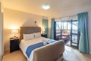 - une chambre avec un lit, un canapé et un balcon dans l'établissement Central Wilderness Bliss - Sleeps 6 - Beach & Lagoon, à Wilderness