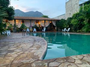 a swimming pool with chairs and a house at Hotel Acapulco Club Diamante in Acapulco