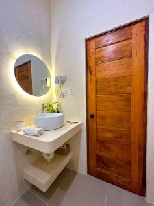 a bathroom with a sink and a wooden door at Moana Dive Resort in Panglao Island