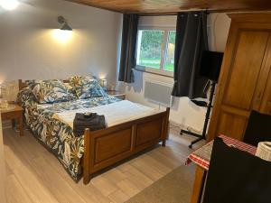 une chambre avec un lit, un canapé et une télévision dans l'établissement Nuit à la campagne, à Assenoncourt